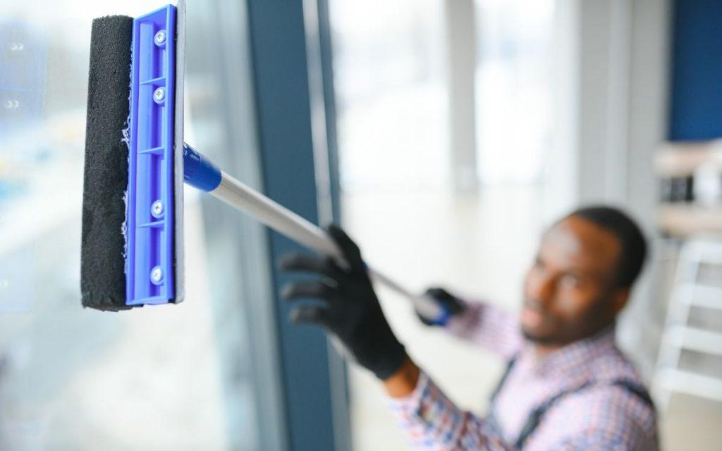 Person cleaning a large window.